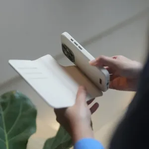 Moshi Overture plånboksfodral för iPhone 15 Pro Max i vitt, visas öppet med en telefon inuti.
