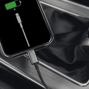 Moshi USB-A-till-Lightning-kabel som laddar en iPhone i en bilinteriör, svart kabel på 1 m
