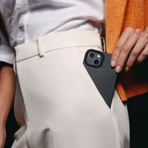 Mujjo Full Leather Case för iPhone 14 i svart, visas delvis i en byxficka med kamerautskärningen synlig