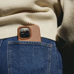Mujjo Full Leather Wallet Case för iPhone 14 Pro Max i brunt läder, instoppat i en jeansficka med kamerautskärning.