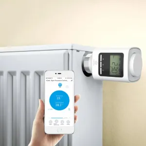 WOOX Zigbee smart radiatorventil monteret på en radiator, med appstyring vist på en smartphone