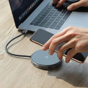Baseus kompakta Type-C-hubb med trådlös laddningsplatta på 10 W bredvid en bärbar dator på ett skrivbord