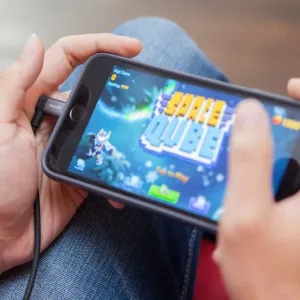 Moshi Lightning-till-USB-kabel med 90-graderskontakt ansluten till en smarttelefon för spel och laddning