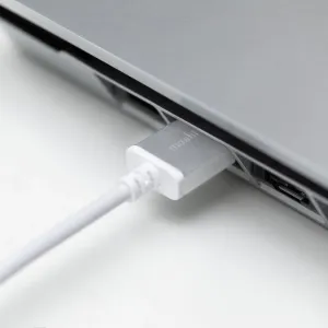 Moshi vit HDMI-kabel ansluten till en grå enhet, visad i närbild på en vit yta.