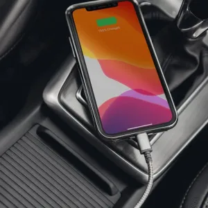 Moshi Integra USB-C till Lightning-kabel som laddar en smartphone i en bilkupé, med Moshi-logotypen synlig