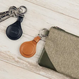 Moshi AirTag-nyckelring i svart veganskt läder med fjäderlås, visad med nycklar och ett fodral