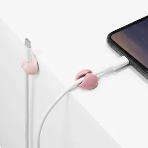 Bluelounge CableDrop Mini kabelhanteringsklämmor i ombre blush som håller laddningskablar på en vit yta