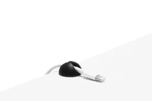 Bluelounge Cable Drop Mini kabelhållare som greppar en vit laddningskabel, svart kupol mot vit bakgrund