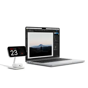 Twelve South HiRise 2 Deluxe trådlöst laddningsställ med en smartphone i liggande läge bredvid en öppen bärbar dator
