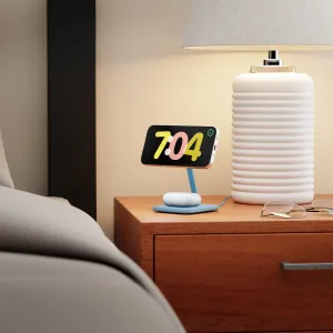 Twelve South HiRise 2 Deluxe laddningsställ för trådlös laddning som håller en smartphone på ett sängbord bredvid en lampa.