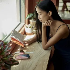 Twelve South Butterfly™ SE rosa trådlös laddare som håller en iPhone och en Apple Watch på en bordsskiva