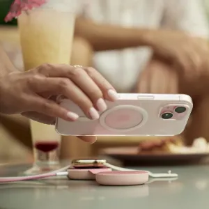 Twelve South butterFly SE rosa hopfällbar trådlös laddare med telefon och Apple Watch på ett bord