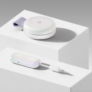 Twelve South AirFly-adapter med kabel, visad bredvid ett runt hopfällbart fodral på ett vitt stativ