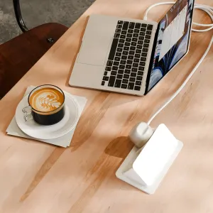 Twelve South PowerCord 3 m vit USB-C-laddare ansluten till en bärbar dator på ett skrivbord i ljust trä