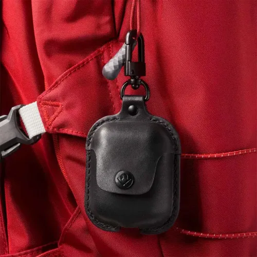 Twelve South AirSnap AirPods-fodral i läder med vridbar klämma fäst på en röd ryggsäcksrem