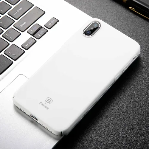 Baseus vitt ultratunt skyddsskal för iPhone X/XS med urtag för dubbelkamera på ett tangentbord till bärbar dator