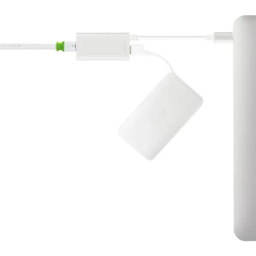 Moshi USB-C-till-Gigabit Ethernet-adapter i vitt, visad ansluten mellan kablar till en dator