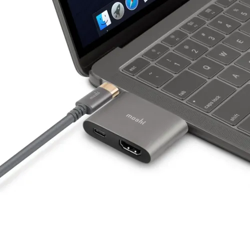 Moshi USB-C-till-HDMI-adapter ansluten till en bärbar dator, med genomströmsladdning och synliga USB-C- och HDMI-portar.