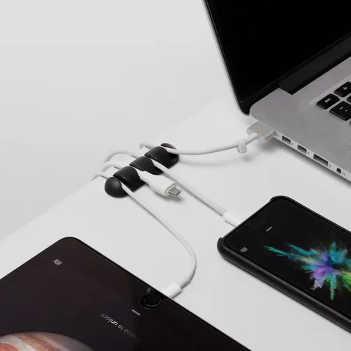 Bluelounge Cable Drop Multi kabelorganisatör som fäster flera laddningskablar på ett rent vitt skrivbord med bärbar dator och telefoner