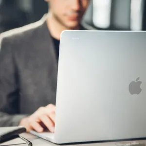 Funda protectora Moshi iGlaze para MacBook Pro de 16 pulgadas en transparente discreto, mostrada sobre un portátil plateado