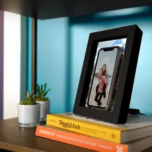 Chargeur sans fil Qi Twelve South PowerPic avec un smartphone présenté dans un cadre photo noir sur un bureau