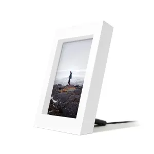 Cargador inalámbrico blanco Twelve South PowerPic Frame con estilo de marco de fotos, con una foto mostrada y un cable conectado