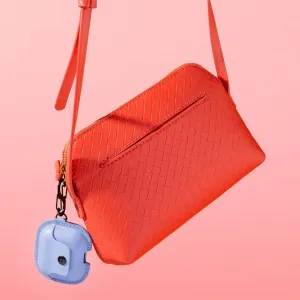 funda de cuero AirSnap para AirPods de Twelve South sujeta a una bolsa tejida roja con clip en S y correa de muñeca