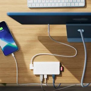 Hub USB-C StayGo de Twelve South en blanco sobre un escritorio, con cables conectados, Ethernet y una tarjeta de memoria insertada