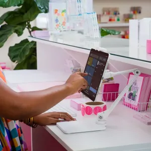Soporte ajustable blanco para iPad Twelve South HoverBar Duo Snap con una tableta sobre un escritorio
