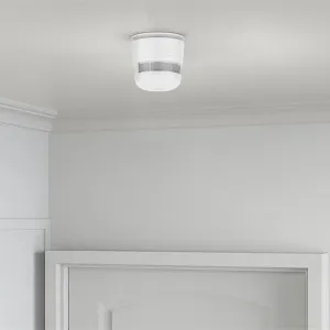 WOOX detector inteligente de humo Zigbee montado en el techo de un interior doméstico, diseño redondo blanco