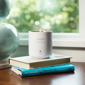 Twelve South Inspire Mac Candle No. 2 tänt doftljus i ett vitt äppelinspirerat keramikkärl på staplade böcker.