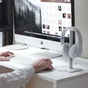 Soporte para auriculares Bluelounge Posto con auriculares blancos de diadema en un escritorio minimalista