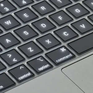 Funda de silicona para teclado Philbert para MacBook Air 2018, protector de teclas negro transparente sobre el teclado de un portátil plateado