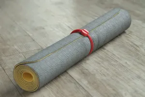 Élastique Bluelounge Pixi maintenant un tapis gris roulé pour un rangement organisé
