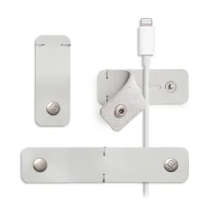 Twelve South CableSnap Stay kabelhållare i läder i duvgrått med tryckknappar och en vit Lightning-kabel