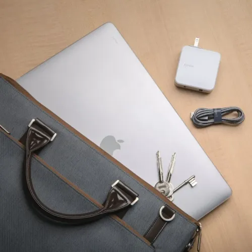 Moshi iGlaze para MacBook Pro de 16" mostrada con un MacBook Pro plateado, una funda, un cable y unas llaves sobre una mesa de madera