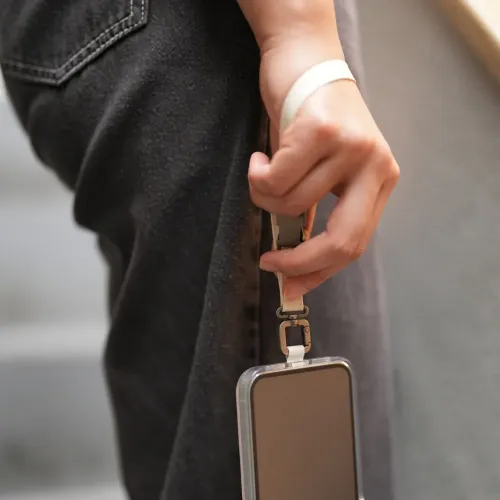 Dragonne/bandoulière 2-en-1 Moshi en blanc Eggnog fixée à une coque de smartphone pour un port mains libres