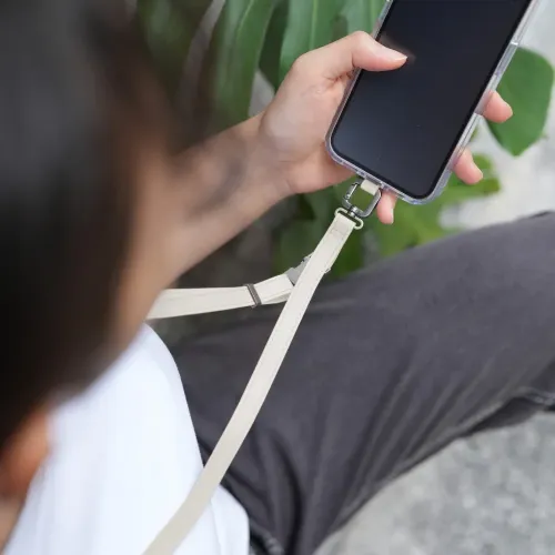 Moshi 2-in-1-Handgelenk-/Körperband in Eggnog White, befestigt an einer Smartphone-Hülle für mobiles Tragen