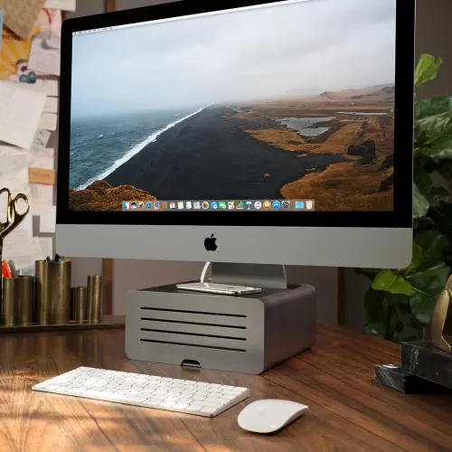 Twelve South HiRise Pro soporte para iMac que eleva un iMac sobre un escritorio, con un teléfono apoyado encima.