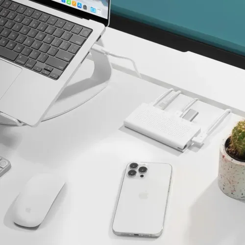 Concentrador USB-C StayGo de Twelve South en blanco sobre un escritorio, conectado a un portátil y accesorios
