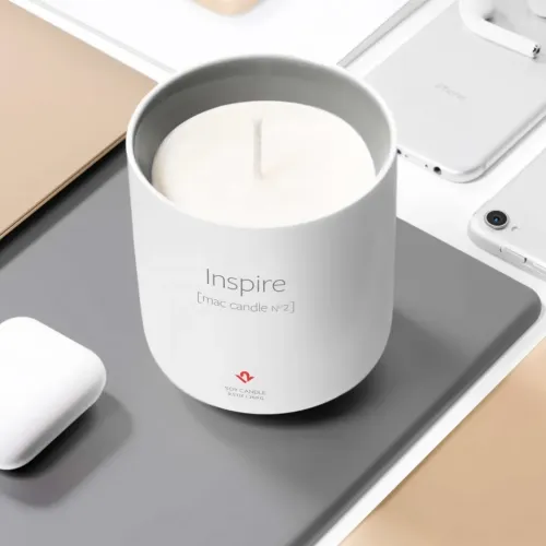 Twelve South Inspire Mac Candle No. 2 i ett vitt Apple-inspirerat keramiskt kärl på ett arrangerat Apple-skrivbord