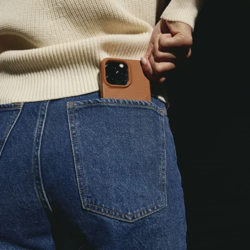 Mujjo plånboksfodral i läder för iPhone 14 Pro Max i en bakficka på ett par jeans, med smal profil och kamerautskärning