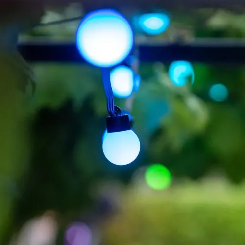 Lite Bulb Moments globe-lysslynge som lyser blåhvitt mot en uskarp grønn bakgrunn