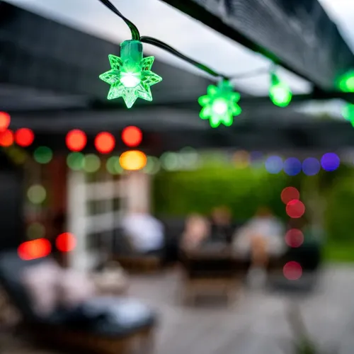 Lite Bulb Moments -älykäs tähtivaloketju, vihreänä hehkuvat tähdet mustassa johdossa ulkoterassilla