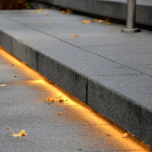 Lite Bulb Moments vandtætte LED-strip oplyser et betontrin udendørs med et varmt ravfarvet skær