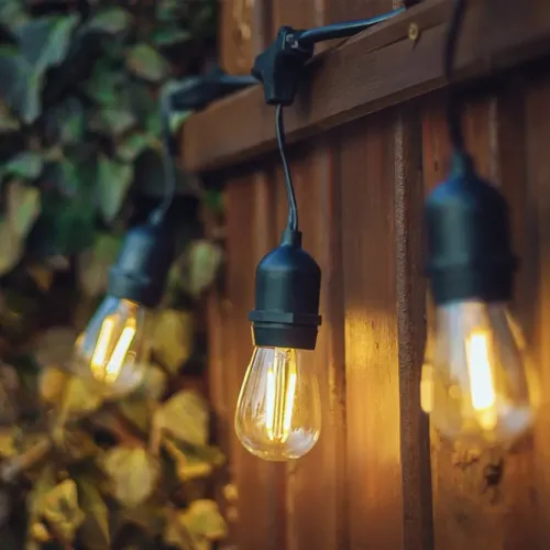 Lite Bulb Moments vintāžas Edison viedā gaismas virtene ar caurspīdīgām spuldzēm, kas spīd uz āra žoga