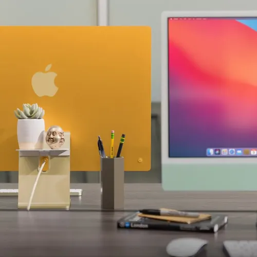 Twelve South BackPack bakmonterad hylla för iMac, som håller en växt och organiserar en kabel bakom skärmen.