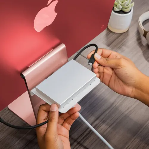 Twelve South BackPack 4-hylla monterad bakom en rosa iMac, med dold förvaring för USB-C-hubb och kablar.