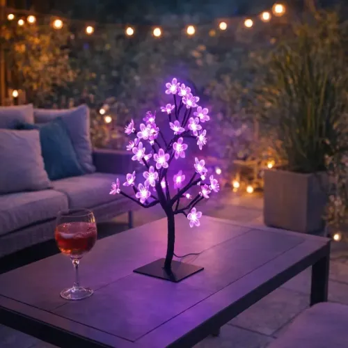 Lite Bulb Moments viedā ķiršu ziedu koka lampa, kas mirdz rozā violetā krāsā uz galda virsmas āra terases vidē