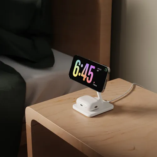 Twelve South HiRise 2 Deluxe trådlöst laddningsställ med vinklad iPhone och AirPods-fodral på ett nattduksbord